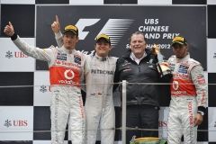 Zleva Jenson Button, vítězný Nico Rosberg, Norbert Haug (šéf Mercedes-Benz Motorsport) a Lewis Hamilton na pódiu v Šanghaji