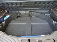 Pod dnem zavazadlového prostoru je místo náhradního kola, nahrazeného sadou na opravy, mělká odkládací schránka; vpravo dole je páka pro uvolnění nosiče kol