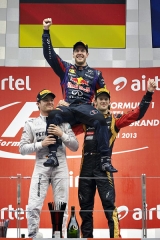 Sebastian Vettel na ramenou rivalů po triumfu v Indii (vlevo Rosberg, vpravo Grosjean)