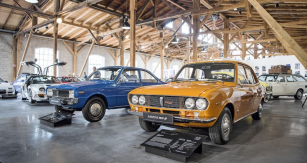 Mazda R100 (modrá) z roku 1971 s dvourotorovým  motorem Wankel. Vedle typ RX-2 ze stejného roku s větším motorem, řadící se o segment výše do střední třídy