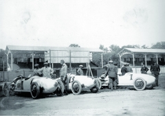 Tým Benz s vozy Benz Tropfenwagen v boxech Velké ceny Itálie 1923. Zleva: st. č. 7 Franz Horner, st. č. 13 Willy Walb a st. č. 1 Ferdinando Minoia.