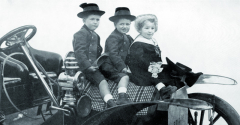 Didier, Guy a René Jellinek, děti z druhého manželství Emila Jellineka na kapotě vozu Mercedes z roku 1905. Za zmínku stojí kromě jiného též pečlivě rozprostřený pléd, na němž děti sedí – jako na opravdovém koni!