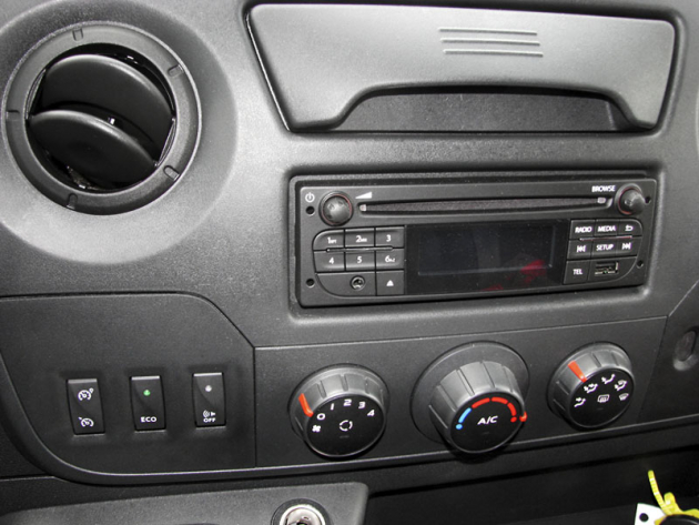 Na středovém panelu jsou rozhlasový přijímač a další ovladače. Krátkou pákou vlevo pod volantem se volí režim jízdy