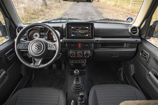 Palubní deska i v nejnovějším provedení typu Suzuki Jimny vyniká robustností a přehledností rozložení ovládacích a komfortních prvků