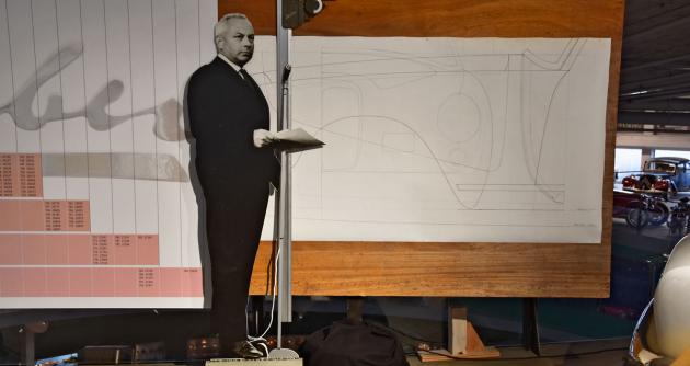 Silueta Hermanna Grabera před jeho původním kreslicím prknem a ­grafem s čísly karosérií různých modelů na 127 šasi Graber