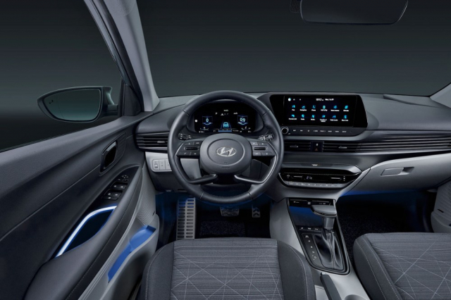 Specifický volant, širokoúhlý dotykový monitor multimediálního systému uprostřed i zdánlivě průběžné linky výdechů ventilace připomínají dražší vozy Hyundai, zejména nový Tucson