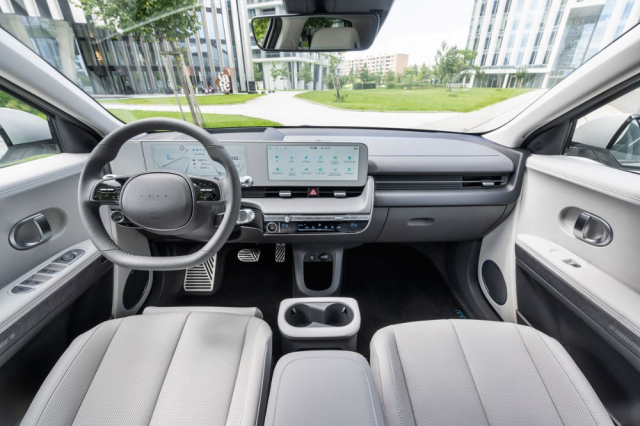 I zásluhou světlých odstínů působí interiér příjemně vzdušným dojmem. Vynikající je výhled všemi směry, ale i klasické rozvržení přístrojů a ovladačů. Všimněte si absence loga Hyundai na volantu. Mezi sedadly je umístěna posuvná konzola a posádku je připraven chránit středový airbag