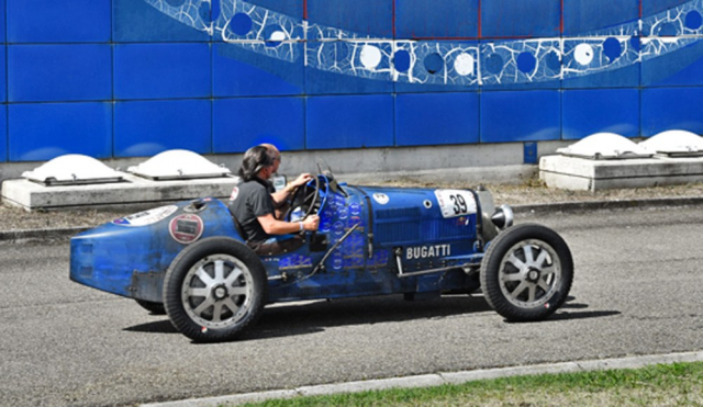 Švýcarský řidič vede Bugatti 35B (1930) Teamu Bugatti na trati časového testu proplétajícího se po areálu uzavřené továrny Bugatti