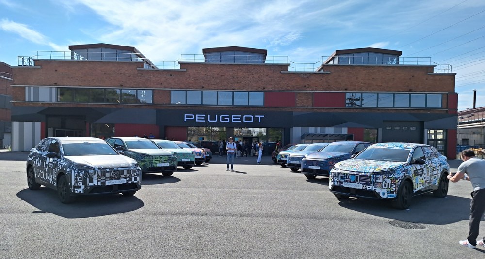 Před továrnou Sochaux, 12. září dopoledne. Zatím ještě maskované prototypy lemují cestu k hale, v níž za chvíli dojde k slavnostnímu odhalení nové generace Peugeotu 3008