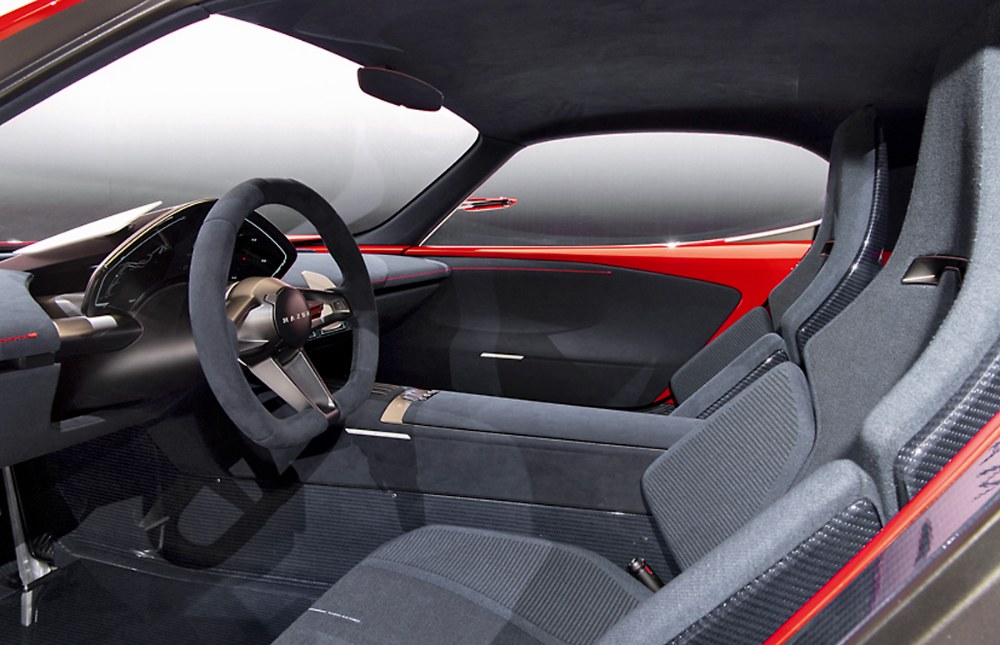 Minimalistický interiér má sedadla s výrazným bočním vedením a tenký, do prostoru vystupující přístrojový štít