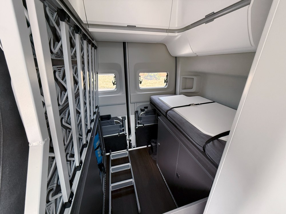 Pod postelí se nachází úložný prostor i plynové lahve. Žebřík zajišťuje snadný přístup do horního lůžka nad jídelní sekcí