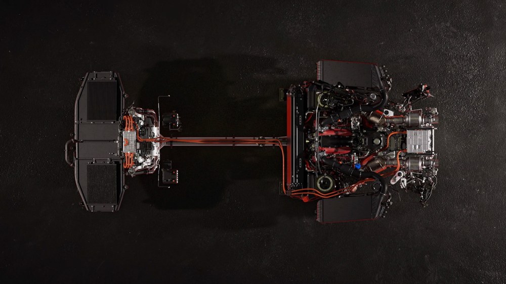 Před motorem umístěným podélně před zadní nápravou je příčně u podlahy umístěn akumulátor. Každé z předních kol pohání jeden elektromotor. Celkově však trojice elektrických ústrojí disponuje výkonem nejvýše 162 kW (220 k)