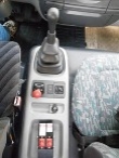 Krátkou řadicí pákou se ovládá přímo řazená převodovka ZF. Na středovém tunelu je za ní ventil parkovací brzdy, kolečko seřizování světlometů, ovladač elektricky seřiditelných zrcátek a až u stěny kabiny ovladače kontejnerového mechanismu